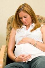 pregnant woman with white shirt sitting on couch